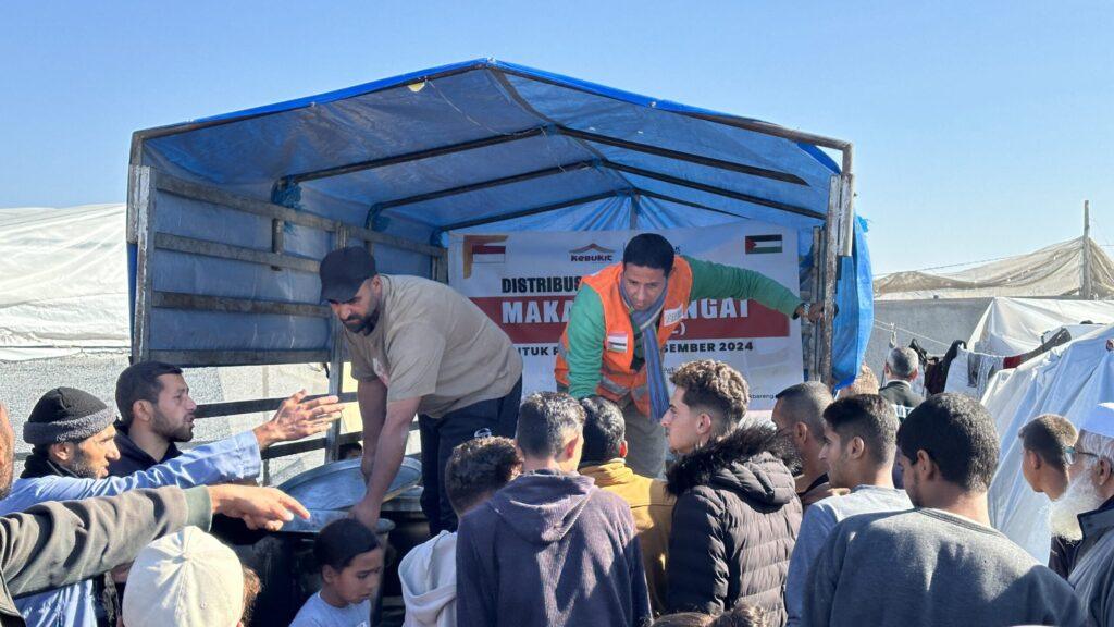 Relawan Gerak Bareng sedang membagikan makanan hangat